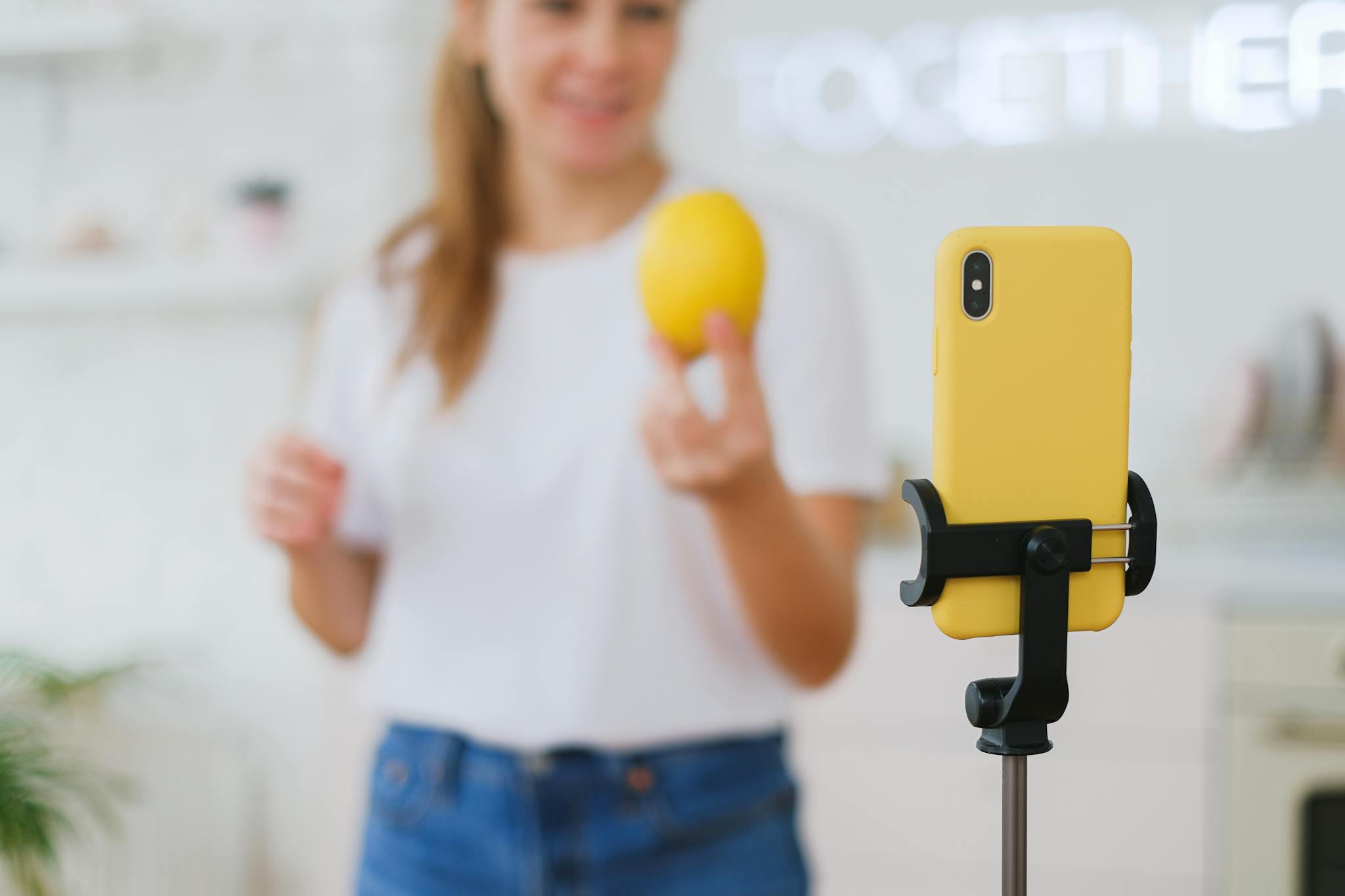 Woman vlogging about cooking with lemon in a home kitchen setting.